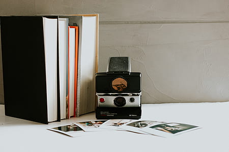 four assorted-title books near camera and pictures thumbnail
