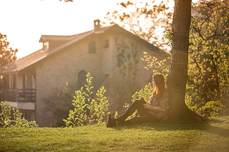 woman sitting under tree far at the house during daytime photography thumbnail