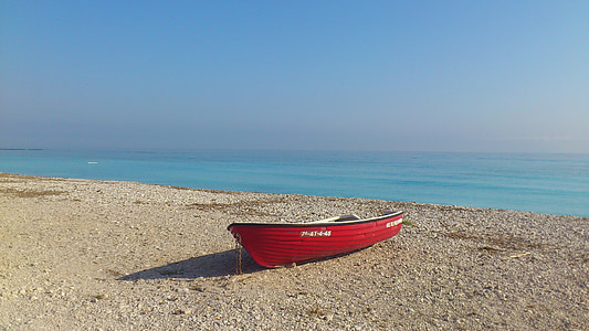 red row boat near body of water during daytime thumbnail