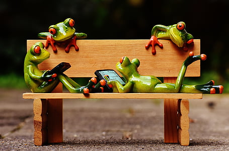four green frog figurines on wooden bench miniature thumbnail