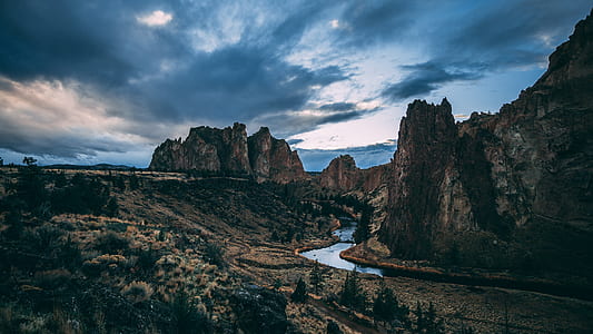 brown rocky mountains under blue cloudy sky during daytime thumbnail