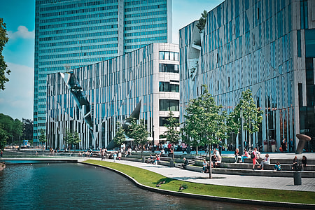 photo of white concrete building near lake under white clouds at daytime thumbnail