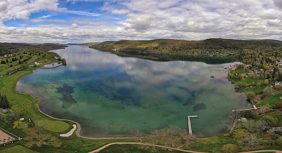 high angle photography of lake surrounded by green leafed trees duing daytime thumbnail