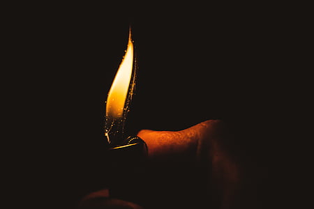 person holds lighted lighter thumbnail