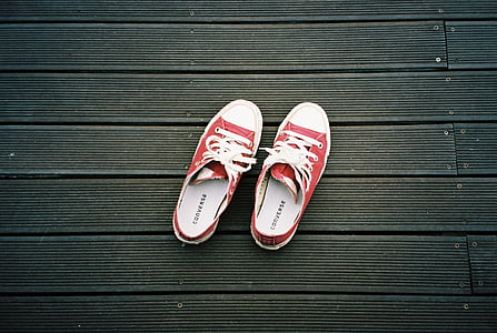 pair of red-and-white Converse All Star low-top sneakers on gray surface thumbnail