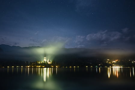 lighted lighthouse under cloudy sky thumbnail