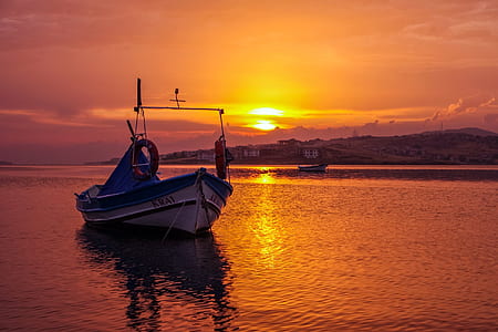 white boat on body of water during golden hour thumbnail