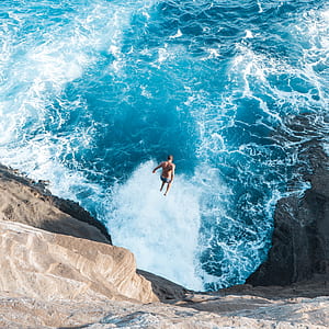 man jumping in to blue body of water thumbnail