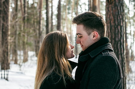 Man Wearing Black Coat Facing Woman Wearing Black Coat Near Tree thumbnail