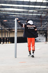 man standing while leaning on post thumbnail