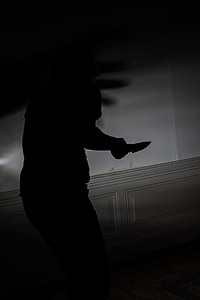 photograph of silhouette person holding a knife thumbnail