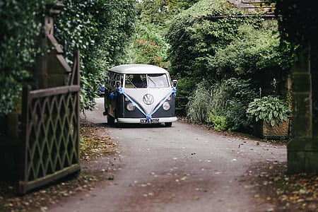 white and gray Volkswagen Kombi approaching gray gate thumbnail