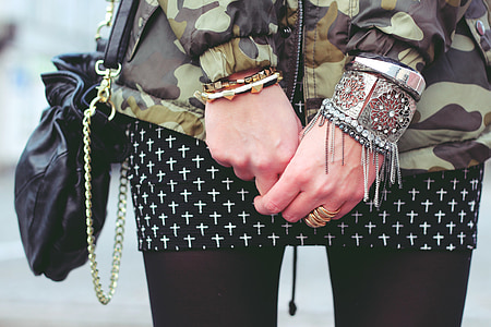 person in green and black camouflage long-sleeved top wearing bracelets and rings thumbnail