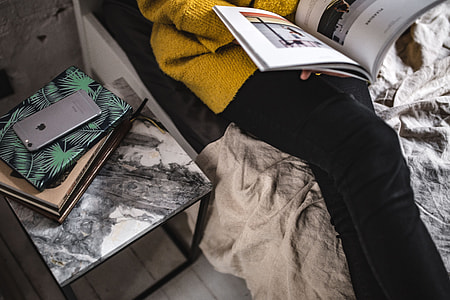 Young woman reading a magazine in bed thumbnail