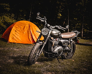 black bobber motorcycle near orange and red tent thumbnail