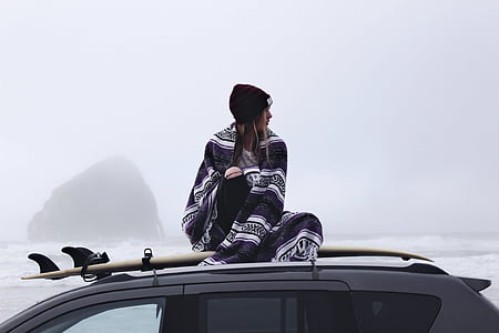girl sitting on top on gray SUV thumbnail