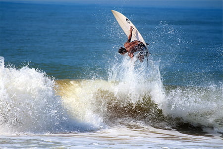 man surfing on wave during daytime thumbnail