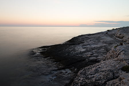 rock formation beside body of water during daytime thumbnail