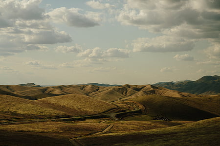 hills under cloudy sky during daytime thumbnail
