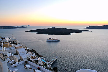 aerial photo of ship on body of water near island at daytime thumbnail