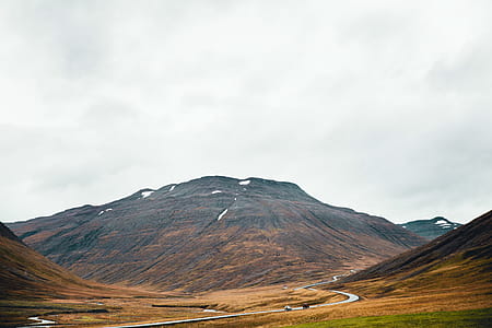 A winding road through volcanic hills on a cloudy day thumbnail