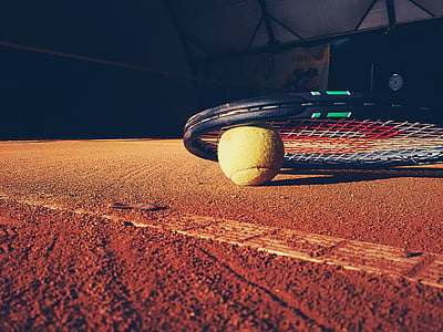 black tennis racket with ball on ground thumbnail