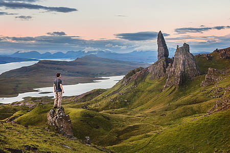 man standing on rock looking at rock formation thumbnail