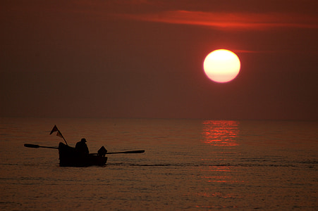 silhoutte of man in boat during sunset thumbnail