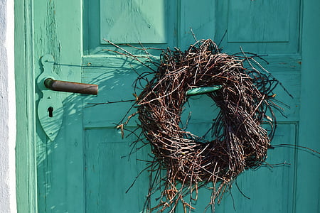 brown wreath on teal wooden closed door thumbnail