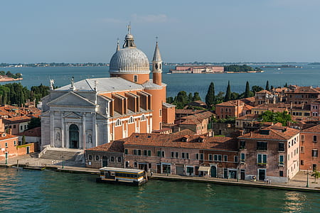 White and Beige Structure Building and Cathedral Near Body of Water during Daytime thumbnail