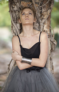 woman wearing black spaghetti strap dress in the back of branch thumbnail