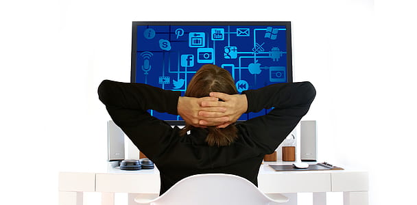 person sitting in front table with computer monitor thumbnail