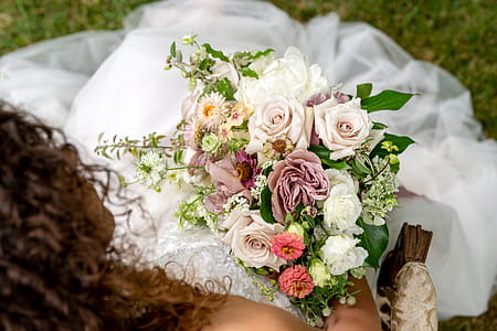 Top View Photography Of Bride Sitting On Grass While Holding Flower Bouquet thumbnail