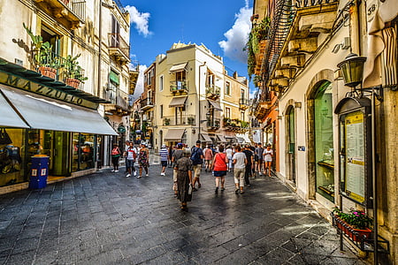 people on road beside buildings at daytime thumbnail