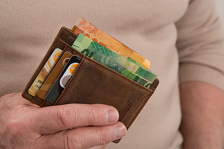 person holding wallet with banknotes and cards in it thumbnail