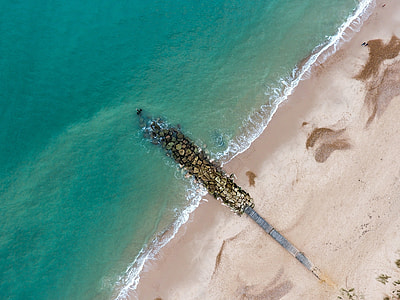 aerial view of waves crashing on rocks thumbnail