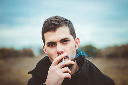 man smoking cigarette during daytime thumbnail