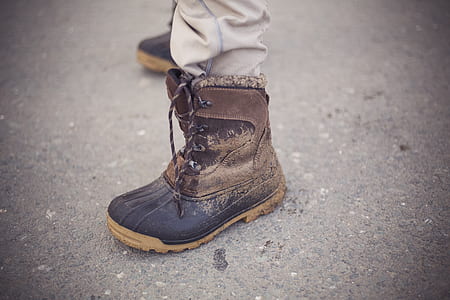 person wearing black and brown leather duck boot on left foot thumbnail