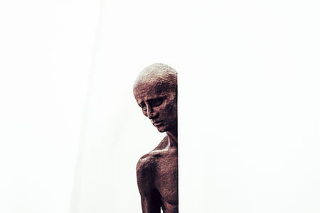 topless person behind white wall thumbnail