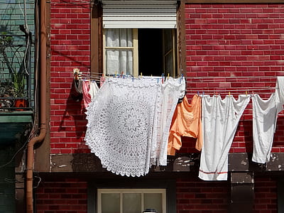 assorted-color clothes hanged near building thumbnail
