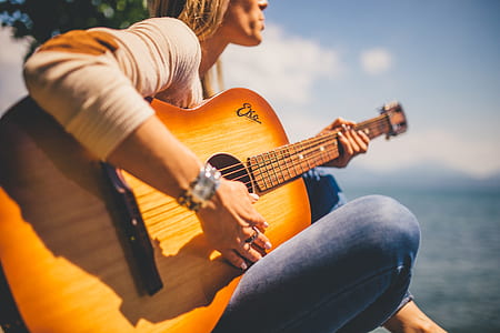 woman wearing sweatshirt playing acoustic guitar thumbnail