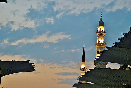 lighted black and beige tower under blue and white sky thumbnail