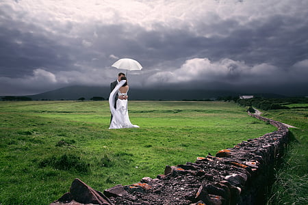 bride and groom under white umbrella thumbnail