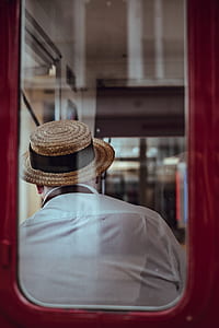 man wearing white shirt and beige straw hat sitting in in vehicle thumbnail