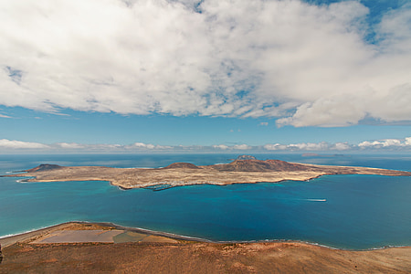 high-angle photography of mountains surrounded by body of water at daytime thumbnail