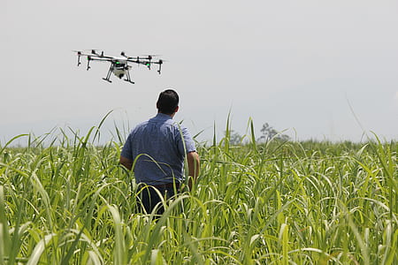 man standing on green grass operating drone at daytime thumbnail