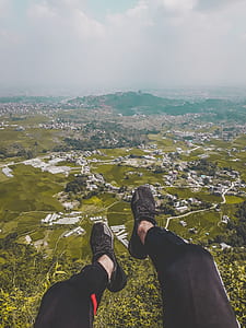 person on hill near village thumbnail