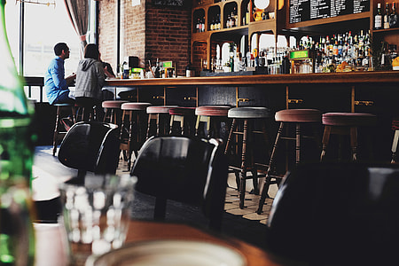 two people sitting on brown wooden chairs thumbnail