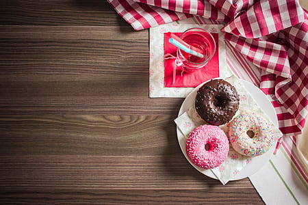 three doughnut place on white ceramic plate beside clear glass cup filled with water thumbnail