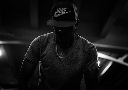 man wearing Nike fitted cap and silver-colored necklace standing inside the building thumbnail